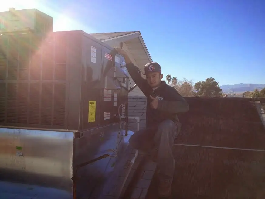 HVAC technician performing Air Duct Repair on a rooftop unit in Cerritos